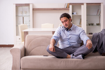 Tired young businessman coming home after working day