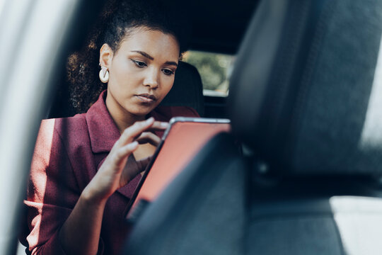 Young businesswoman using digital tablet while sitting in car