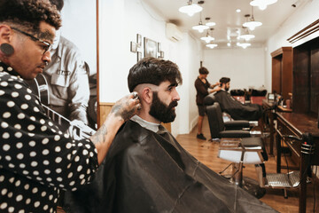 Trendy barber styling client's hair at salon