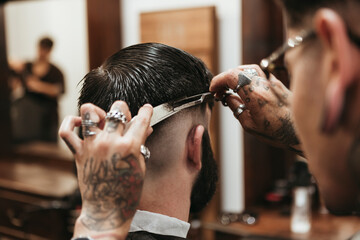 Barber cutting man's hair at salon