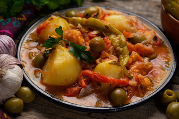Mexican style cod called a la vizcaina on wooden background