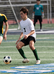 Obraz premium Athletic young boy playing in a competitive soccer game