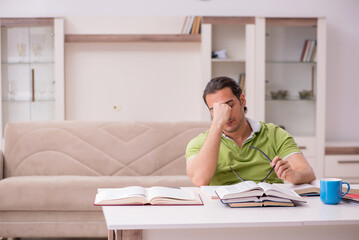Obraz premium Young male student preparing for exams at home