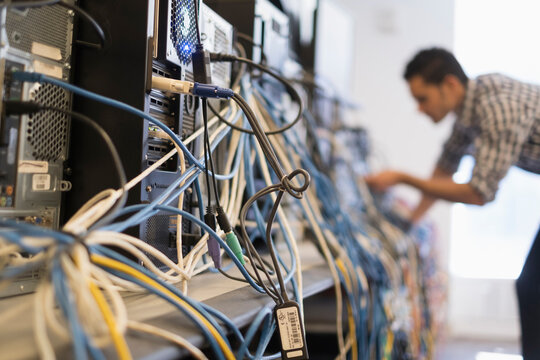 Tangled cables with young technician man in background