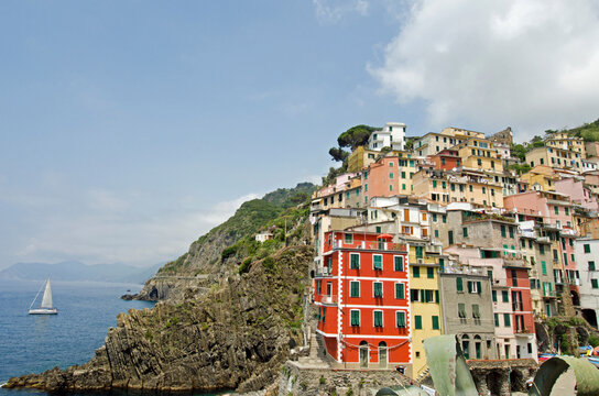 Italy, Cinque Terre, Riomaggiore, Multi colored buildings on hill by sea