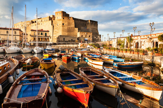 Colorful boats and Castel dell' Ovo at night
