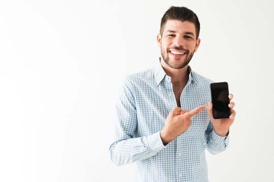 Smiling man is holding his cellphone and showing a blank black screen