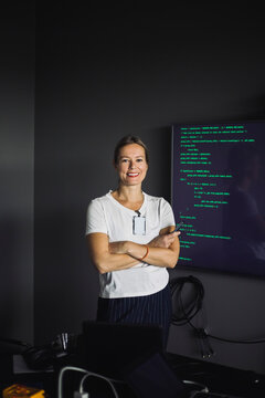 Portrait of smiling IT professional working on projection screen in creative office