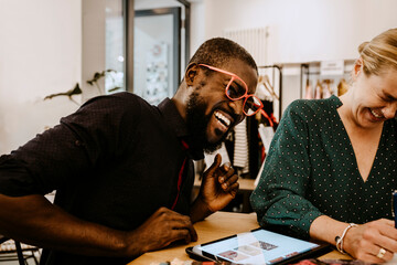 Cheerful employee and female owner working while using digital tablet in store