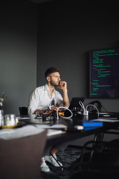 IT professional with hand on chin contemplating in creative office