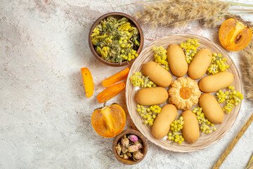 a plate of cookies and bowls of dry lavender and flower and emmers and palms on marble background