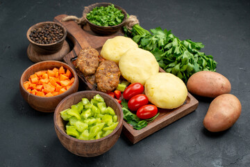 Cutlet meal with chopped vegetables a bunch of green and ketchup for on dark background