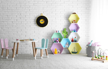 Child room interior with colorful shelves near brick wall