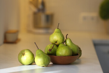 Fresh ripe pears on white countertop in kitchen