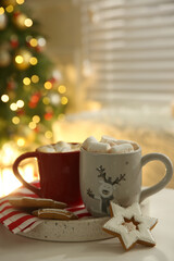 Cups of hot drink on white table indoors
