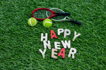 Tennis with word happy new year on green grass