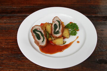 Chicken breast stuffed with spinach, served with sauteed potatoes and sauce