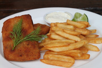 Crumbed salmon trout stuffed with cheese, served with French fries, carrots and sauce tartar