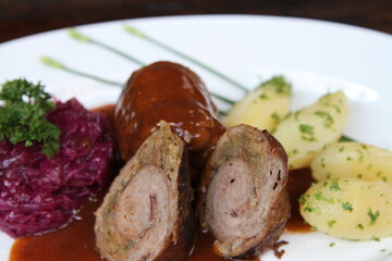 German beef roll stuffed with pickles, smoked ham, onions and mustard served with parsley potatoes, red cabbage and gravy