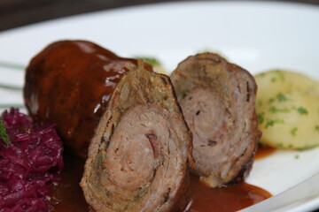 German beef roll stuffed with pickles, smoked ham, onions and mustard served with parsley potatoes, red cabbage and gravy