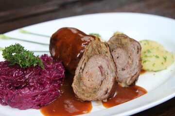 German beef roll stuffed with pickles, smoked ham, onions and mustard served with parsley potatoes, red cabbage and gravy