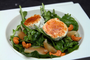 Grilled and caramelized goat cheese served with arugula salad, sauteed pears and cashew nuts