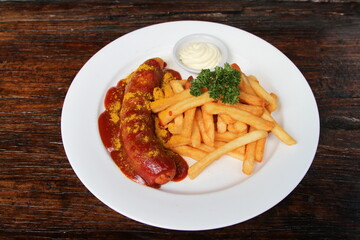 Currywurst, German fried pork sausage seasoned with curry ketchup, served with French fries and mayonnaise
