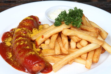 Currywurst, German fried pork sausage seasoned with curry ketchup, served with French fries and mayonnaise