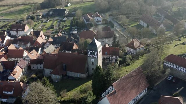 Drone aerial view of the fairytale castle Adelebsen on a beautiful autmn afternoon in golden sunlight. Adelebsen is a historic medieval town Flecken near G&ouml;ttingen in Niedersachsen, Germany.