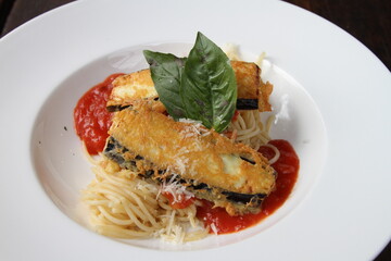 Crumbed fried eggplant on spaghetti with tomato sauce