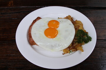 Bavarian meatloaf served with fried potatoes and fried eggs