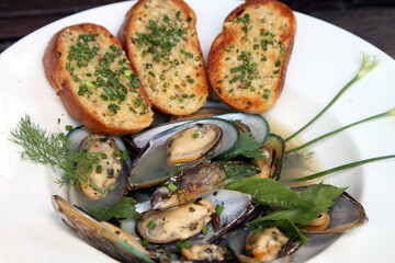 Green shell mussels in herb broth with garlic bread