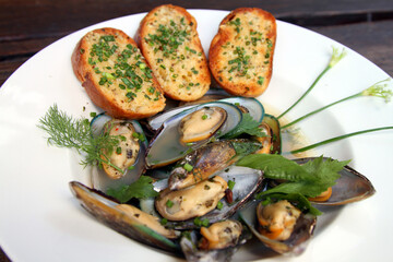 Green shell mussels in herb broth with garlic bread