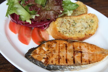 Grilled salmon with salad and garlic bread