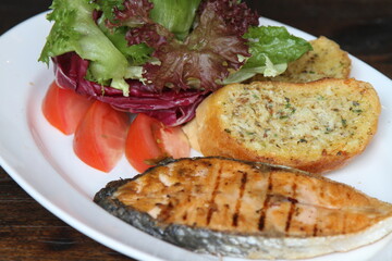 Grilled salmon with salad and garlic bread