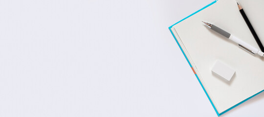 open notebook with blank pages workplace composition, White pencil eraser black pencil for drawing on a white table for school concept with copy space, Top view, flat lay