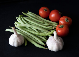 a collection of green beans, tomatoes and garlic