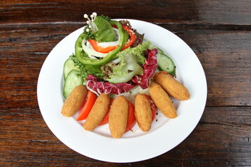Baked Mozzarella served with a mixed salad on white plate