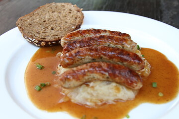 3 Nuremberg sausages on sauerkraut, served with sourdough bread and gravy