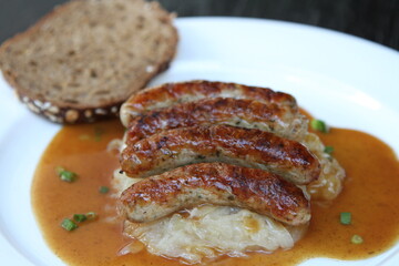 3 Nuremberg sausages on sauerkraut, served with sourdough bread and gravy