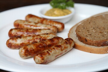 6 Nuremberg sausages served with slices of breads and sweet Bavarian mustard