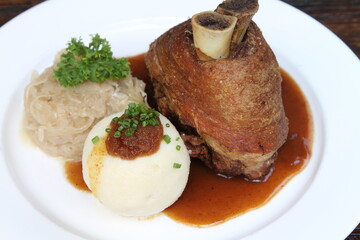 Bavarian pork knuckle with potato dumpling and sauerkraut on gravy