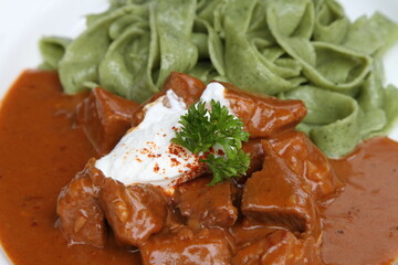 Veal goulash with spinach tagliatelle pasta