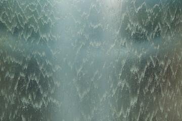 water flowing behind glass with top heavenly light.