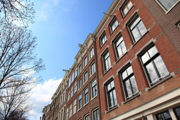 Fototapeta premium オランダの首都アムステルダムの運河沿いに建ち並ぶレンガ造りの家