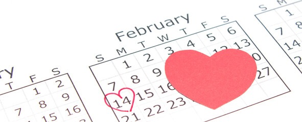 Calendar page with mark valentines day in red circle. February with handmade paper heart. Horizontal banner, copy space.