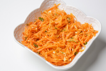 Simple carrot salad in a bowl, fresh and healthy vegetarian meal with parsley and garlic dressing