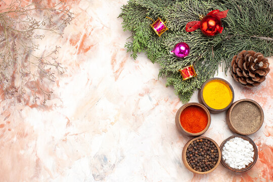 top view different seasonings with christmas tree and toys on light background photo fruit color juice free place