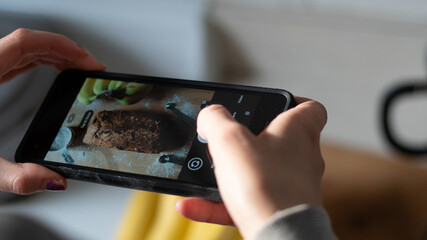 Woman taking picture of banana bread with iPhone