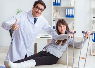 Obraz premium Doctor examining patient with broken leg